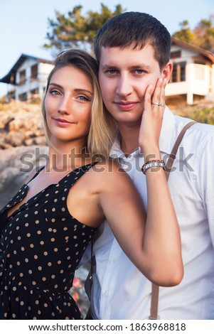 Summer romantic portrait of cute couple hugs near sea, vacation mood. Soft toned colors.