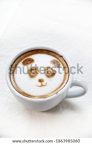A cute Panda face picture on surface of a hot cup of Cappuccino