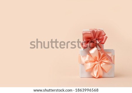 Happy womens day design template. A decorative white gift boxes with a peach bow. Valentine's day concept. Copy space .
