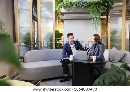 Caucasian business people is working on new strategic planning for next year using laptop while working in green eco friendly modern working space surrounded by air purifying house plant Royalty-Free Stock Photo #1864000498