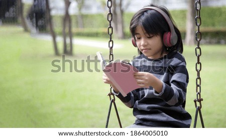 introvert mindset in digital generation of asian kids happy with music in earphone  at park alone in the park