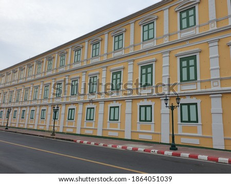 Yellow building with vintage style concatenation green windows.