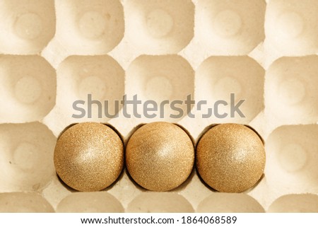 Top view easter composition with golden eggs, creative spring holiday flat lay with painted chicken egg. Beige monochrome photography