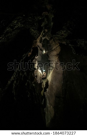 Cavers exploring an uncharted cave Royalty-Free Stock Photo #1864073227