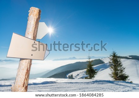 Blank arrow sign with copy space high in the mountains. Focus on sign