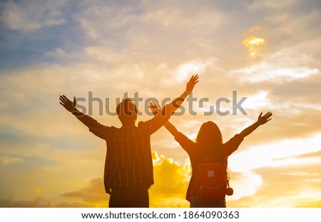 Young woman and young man standing raised his hand in outdoor to breathe pure air, 