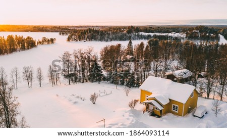 Aerial view from drone of frozen lake covered by white snow near small cozy village with colorful houses on north, bird’s eye view of Lapland countryside land with scenery environment 
 Royalty-Free Stock Photo #1864093114