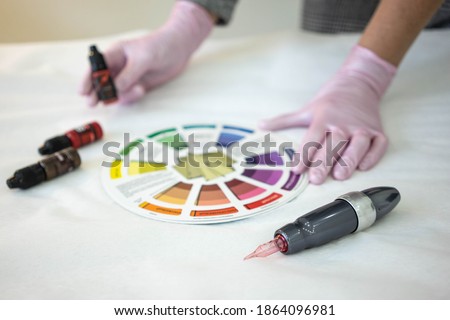 
the permanent makeup artist selects the color using the color wheel Royalty-Free Stock Photo #1864096981