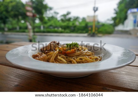 close up Plate of Italian spaghetti aglio olio with tomato on rustic wood.