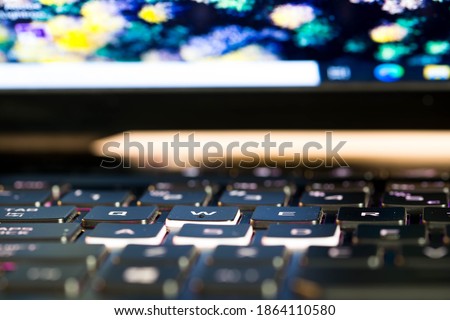 Glowing rgb keyboard on opened gaming laptop close up macro shot for background.