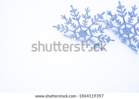Snowflakes in the snow. Christmas snowy background with a pair of snowflakes. Christmas background with empty field for text.