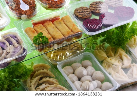 A variety of prepackaged food products in plastic boxes.