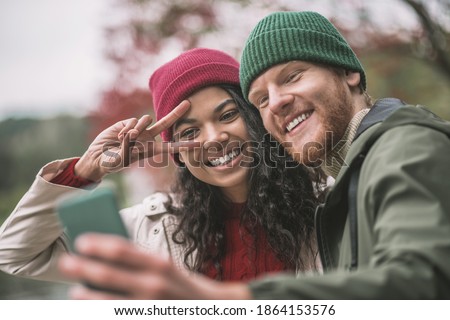 Mobile shooting. A happy couple taking pictures with a smartphone