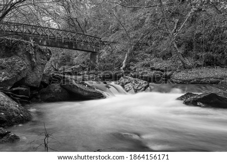 Long exposure of the East Lyn river flowing under a bridge at Watersmeet in Exmoor National Park