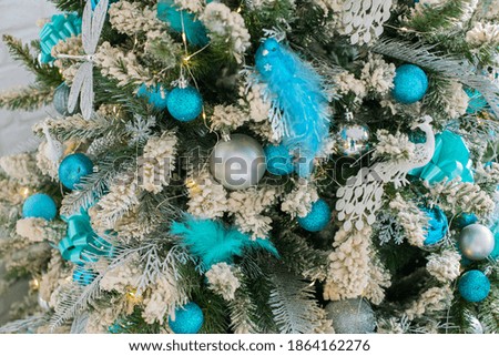 Christmas tree decorated with blue and silver balloons and a bird toy