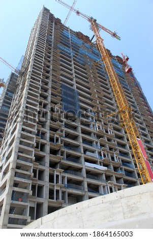 Apartment Buildings Under Construction Using Tower Cranes Viewed From Below.