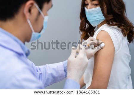 doctor holding syringe and using cotton before make injection to patient in a medical mask. Covid-19 or coronavirus vaccine Royalty-Free Stock Photo #1864165381