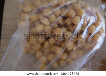 Turkish boiled chickpeas. Putting in a transparent plastic bag for freezing. Selective focus close up. Process of making frozen chickpea. It is called "Kislik Nohut", "Dondurulmuş Nohut" in Turkish.