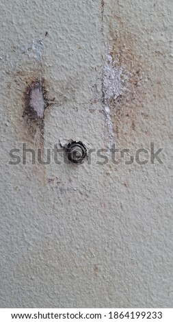 Bolt and nut on the concrete wall.
