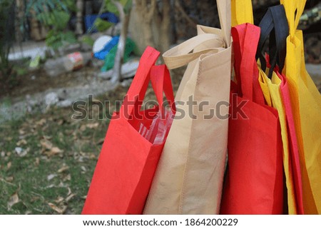 Colorful Grocery Shopping bags isolated on green grass background. Single use Environment friendly bags. Carry bags with copy space for text and logo for you business