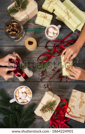 Girls seal gifts and drink cocoa with marshmallows