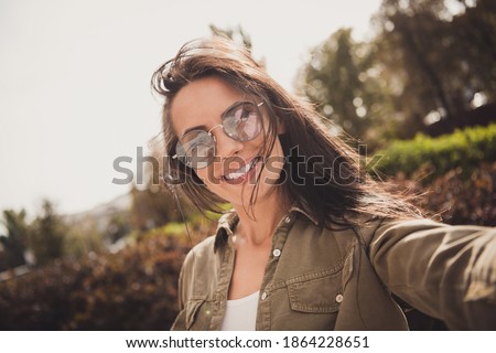 Photo of cheerful lovely funny lady make selfie toothy white smile wear brown shirt eyewear park street outdoors