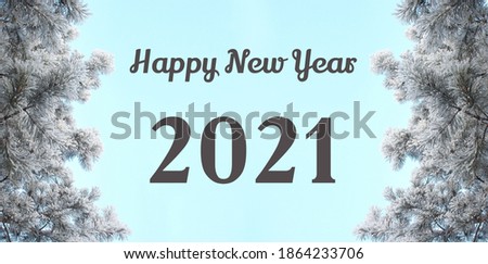 Happy New Year 2021 words. Winter landscape with blue sky. Snow covered frozen pine tree