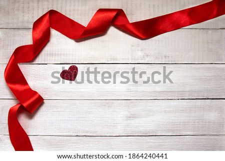 flats composition with a red heart and ribbon on a white wood background. Valentine's Day