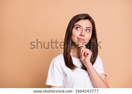 Photo portrait of dreamy girl thoughtful looking copyspace touching chin isolated pastel beige color background