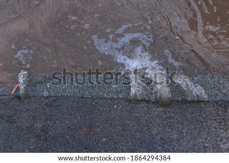water flows from under the asphalt to the road