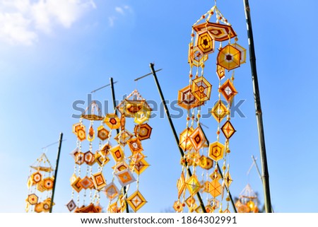 Hanging handmade hexagonal colorful knitting yarn flags suspended from bamboo pole for decoration and celebrating cultural festival of Thailand during summer. Colorful drape, Blown in the traditional