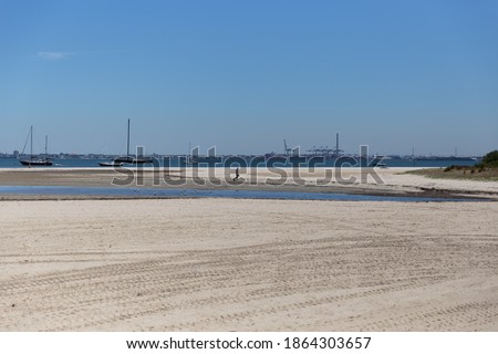 A picture of the beach, with a women walking her dog and the horizon