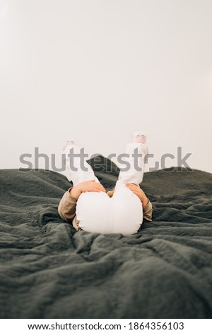 Funny picture of child with butt on the bed. Happy kid playing games
