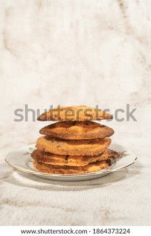 Home made chocolate cookie on an old platei shot on white textured background. 