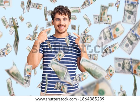 Young handsome man with curly hair wearing casual clothes smiling cheerful showing and pointing with fingers teeth and mouth. dental health concept.