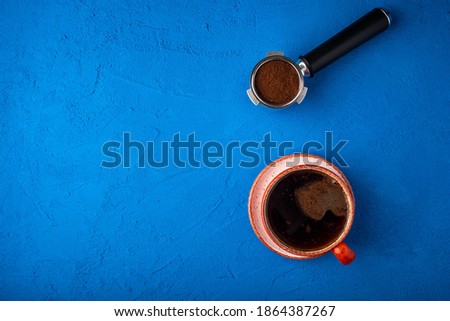 Cup of coffee on a blue background. Making coffee. View from above