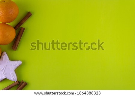 Tangerines, cinnamon and gingerbread on a light green background. Top view, copy space.