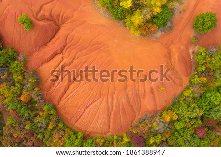 Gant, Hungary - Aerial view of abandoned bauxite mine, bauxite formation, The red mountains resembling Martian landscape. Red and orange colored surface, bauxite texture. Warm fall colors, autumn mood