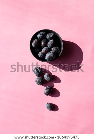 Plums isolated on pink background. Still life photography. Fruit pattern. Minimal, colorful photography.