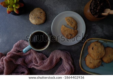 table situation with some cookies and coffee at dark mood flat lay angle