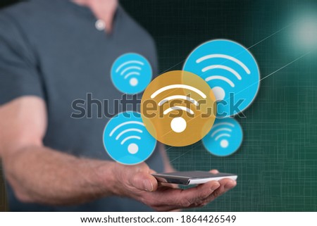 Wifi concept above a smartphone held by a man in background