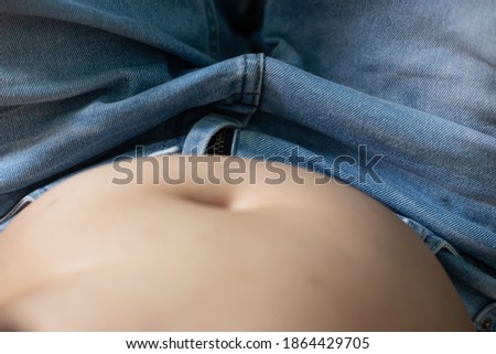 Blurred picture of women overweight showing her fat belly, after enjoy eating.