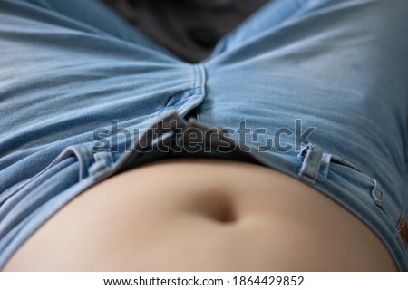 Blurred picture of women overweight showing her fat belly, after enjoy eating.