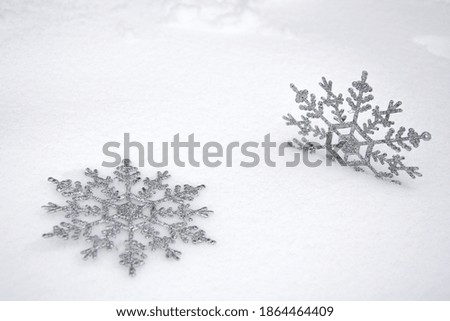 Snowflakes in the snow. Christmas snow background with two snowflakes. Christmas background.