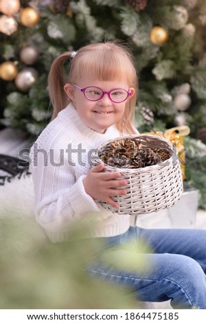 Portrait of a girl with down syndrome among white pillows. On the outdoor Christmas porch.