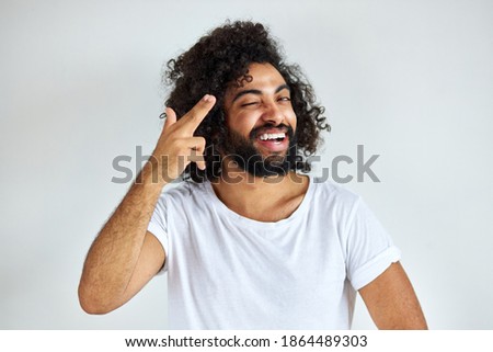 portrait of cheerful positive male of arabic appearance looking away laughing, he listen to joke, have fun with someone, isolated over white background