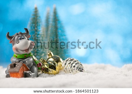 Christmas decoration with natural blurred background. The symbol of 2021 bull and Christmas balls stand