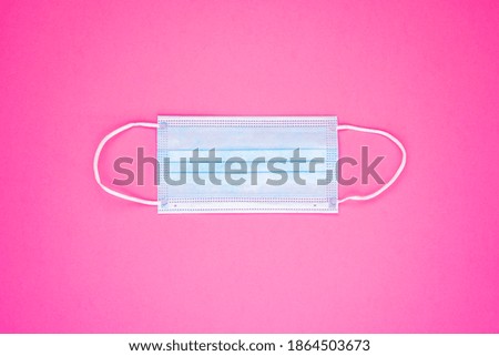 Antibacterial medical mask of blue color on a pink background. Coronavirus Protection concept. Hight quality photo