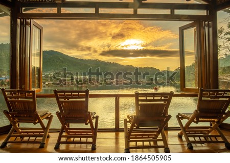 lake view at coffee shop in the morning sunrise, Ban Rak Thai village, landmark and popular for tourists attractions, Mae Hong Son province, Thailand. Travel concept Royalty-Free Stock Photo #1864505905