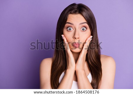 Photo portrait of cute pouting girl touching face cheeks with two hands isolated on vivid violet colored background